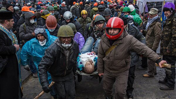 Сторонники оппозиции несут раненного во время столкновений с сотрудниками правопорядка на площади Независимости в Киеве Сторонники оппозиции несут раненного во время столкновений с сотрудниками правопорядка на площади Независимости в Киеве