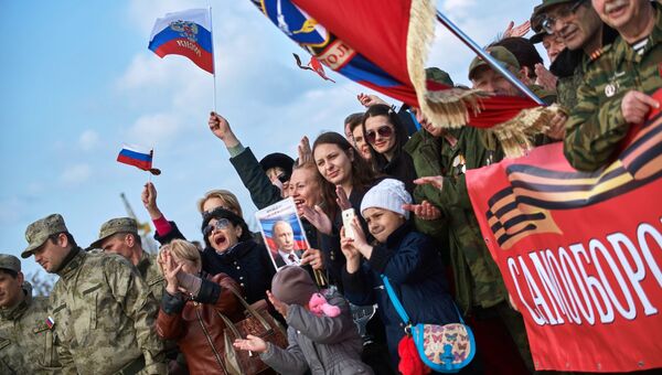 Участники митинга в честь третьей годовщины воссоединения Крыма с Россией на мысе Хрустальный в Севастополе