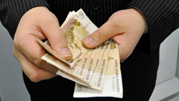 Мужчина держит в руках купюры российских рублей