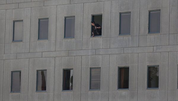 Иранский полицейский в окне здания парламента в Тегеране. 7 июня 2017