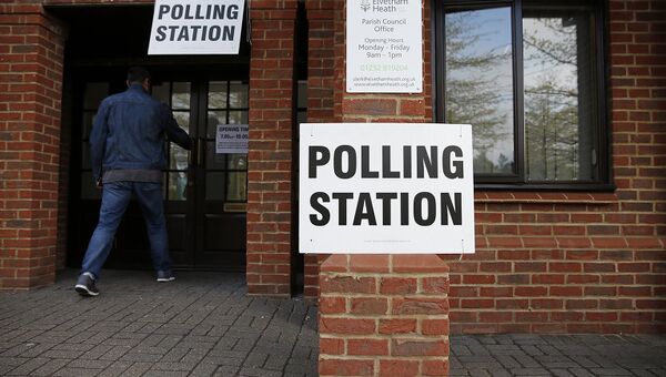 Мужчина заходит на избирательный участок во время парламентских выборов в Великобритании