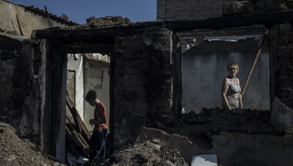 Жители в пострадавшем во время обстрела поселке Старомихайловка Донецкой области