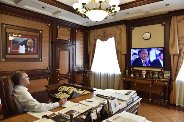 Глава Республики Крым Сергей Аксенов в своем кабинете смотрит прямую линию с президентом РФ Владимиром Путиным