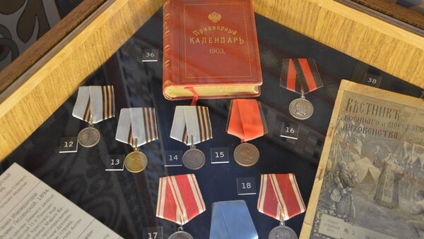 Золотые и серебряные нагрудные медали, придворный календарь императора. Экспонаты древлехранилища памяти семьи императора Николая II в Крестовоздвиженской дворцовой церкви в Ливадии