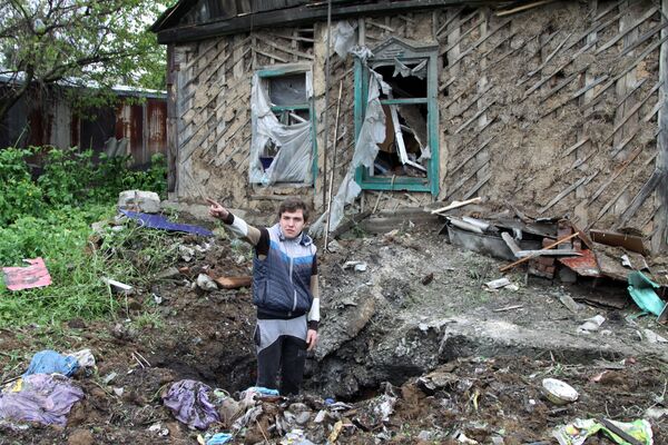 Житель Донбасса демонстрирует последствия обстрела со стороны украинских силовиков. Архивное фото Житель Донбасса демонстрирует последствия обстрела со стороны украинских силовиков. Архивное фото