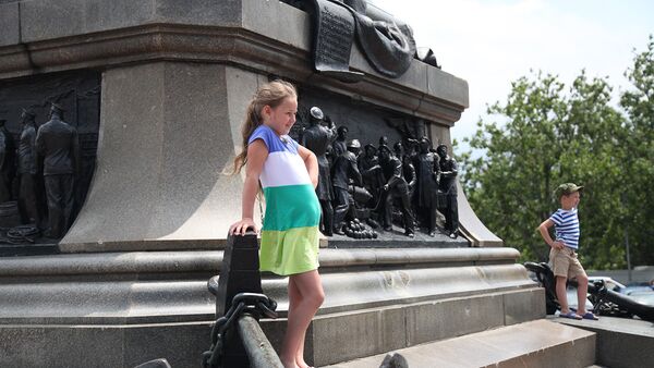 Дети фотографируются у памятника адмиралу Нахимову в Севастополе
