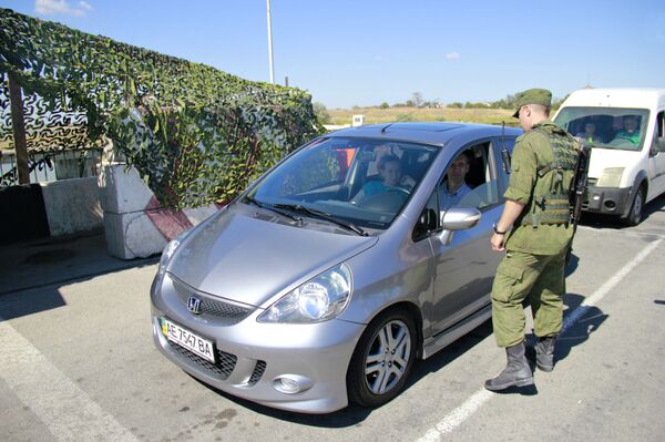 Люди на автомобилях проходят пограничный контроль на границе России и Украины Люди на автомобилях проходят пограничный контроль на границе России и Украины