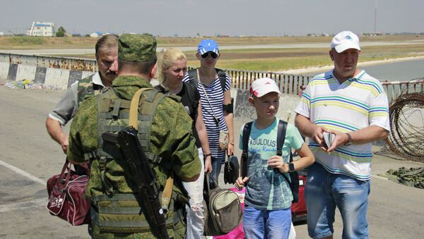 Люди с детьми в пункте пропуска Джанкой на границе России и Украины