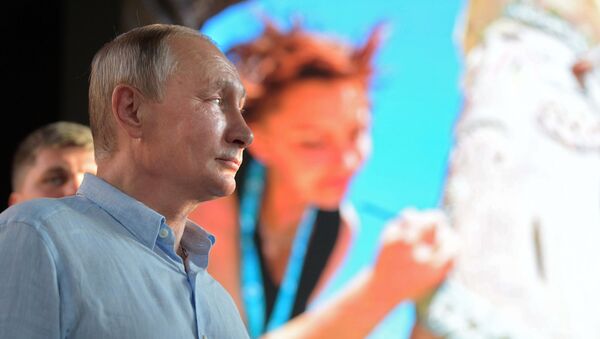 Президент РФ Владимир Путин знакомится с тематическими выставками творческих групп во время посещения ежегодного Всероссийского молодежного образовательного форума Таврида на Байкальской косе. 20 августа 2017