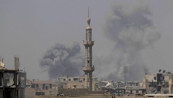 Дым после авиаудара в Ракке, Сирия