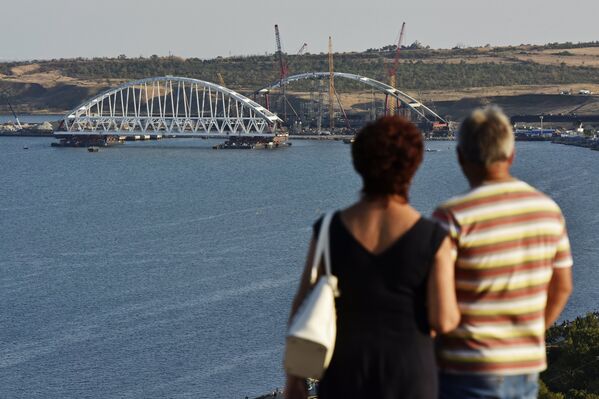 Люди смотрят на морскую операцию по транспортировке железнодорожной арки Крымского моста