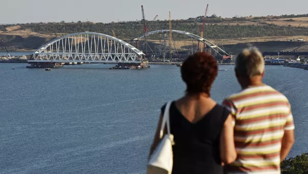 Люди смотрят на морскую операцию по транспортировке железнодорожной арки Крымского моста