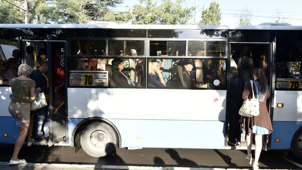 Люди заходят в переполненный автобус на остановке в Симферополе