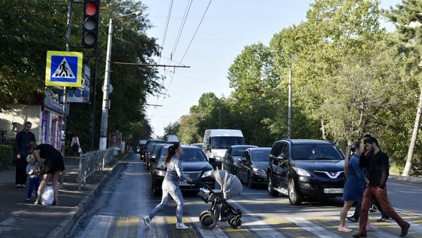 Люди переходят по пешеходному переходу дорогу в Симферополе