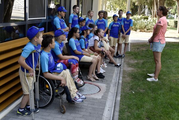 Дети с ограниченными физическими возможностями на смене в МДЦ Артек общаются с вожатой отряда
