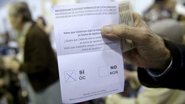 Мужчина держит бюллетень на избирательном участке в Барселоне, Испания. 1 октября 2017