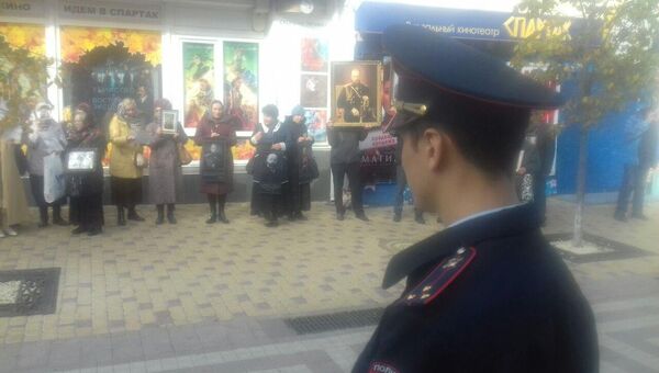 Полицейский наблюдает за протестующими против показа фильма Матильда возле кинотеатра Спартак в Симферополе