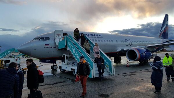 Пассажиры выходят из самолета в аэропорту Симферополь