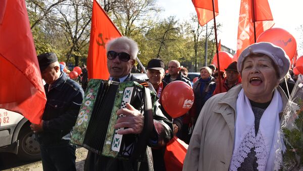 Участник шествия в честь 100-летия Великой Октябрьской социалистической революции в Симферополе поют песни под баян