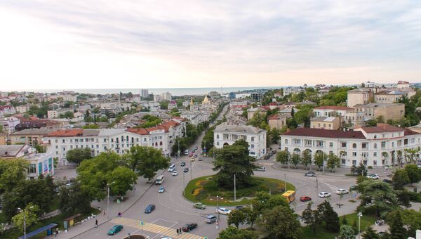 Фото руферов с видом на городские улицы с крыши одного из зданий в Севастополе