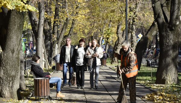 Дворник подметает тротуар в Симферополе. Осень