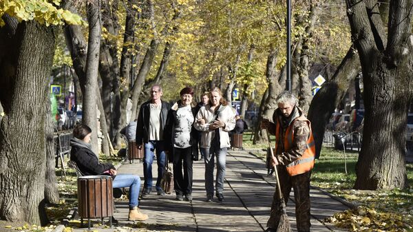 Дворник подметает тротуар в Симферополе. Осень