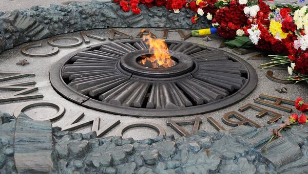 Местные жительницы возлагают цветы к Могиле Неизвестного солдата в парке Вечной славы в Киеве