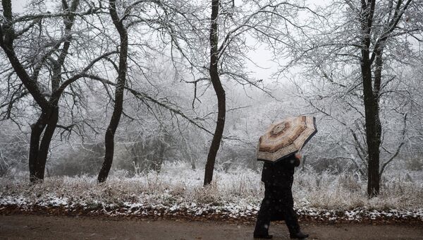 Прохожий во время снегопада в поселке Научный в Крыму