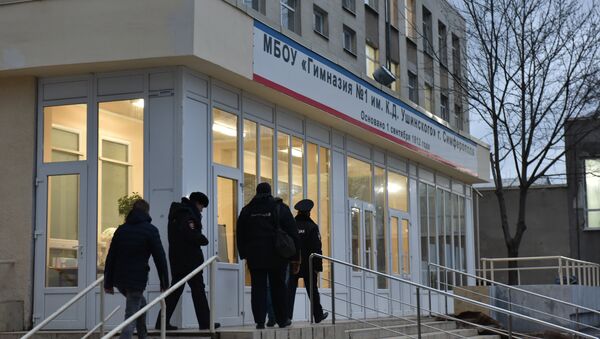 Сотрудники правоохранительных органов заходят в здание гимназии №1 им. К. Д. Ушинского в Симферополе после инцидента со стрельбой