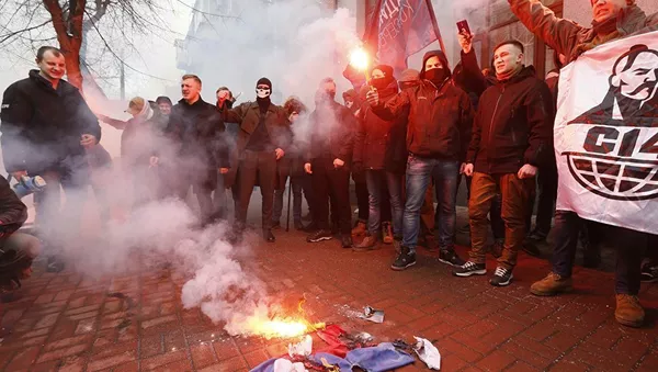 Активисты и сторонники украинских националистов сжигают российский флаг, взятый в здании Россотрудничества в Киеве. 17 февраля 2018
