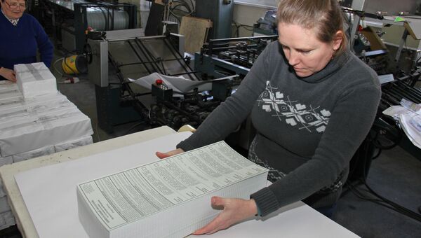 Сотрудник типографии Таврида складывает напечатанные бюллетени