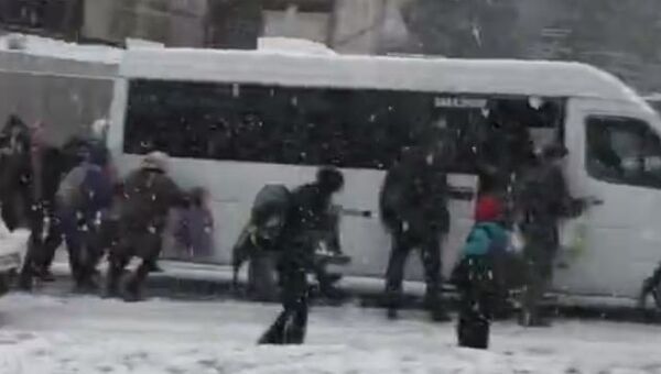 Пассажиры толкают застрявшую в снегу маршрутку в Севастополе