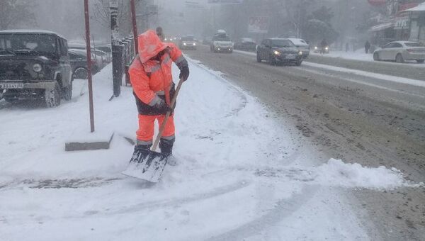 Дворник расчищает обочины дорог от снега в Симферополе. 1 марта 2018