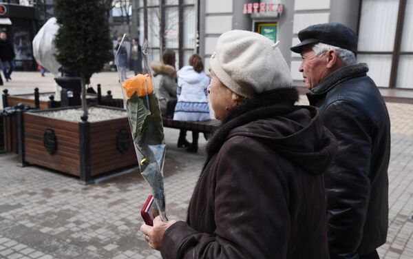 Пожилая пара с цветами в центре Симферополя Пожилая пара с цветами в центре Симферополя