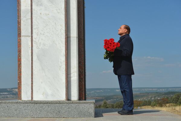 Экс-премьер Италии Сильвио Берлускони возлагает цветы у мемориала, посвященного памяти погибших в Крымской войне солдат Сардинского королевства, неподалеку от горы Гасфорта в Крыму перед встречей с президентом России Владимиром Путиным. 11 сентября 2015 года