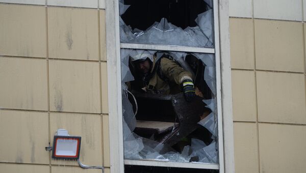 Сотрудник пожарной охраны МЧС во время тушения пожара в торговом центре Зимняя вишня в Кемерово