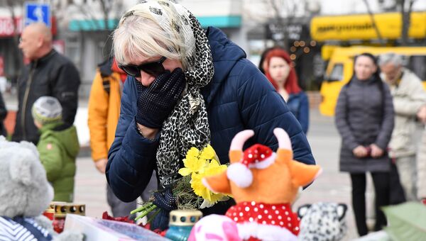 Горожане несут на площадь им. Ленина в Симферополе игрушки и цветы в память о погибших на пожаре в ТЦ Кемерово