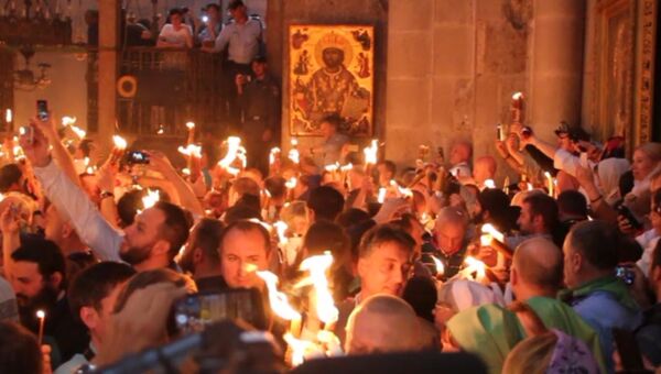Верующие зажигали свечи и факелы от Благодатного огня в Иерусалиме