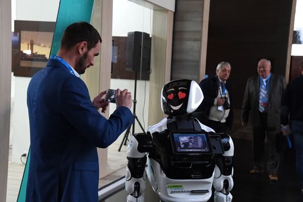 Участники IV Ялтинского международного экономического форума делают фото с роботом