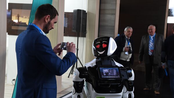 Участники IV Ялтинского международного экономического форума делают фото с роботом