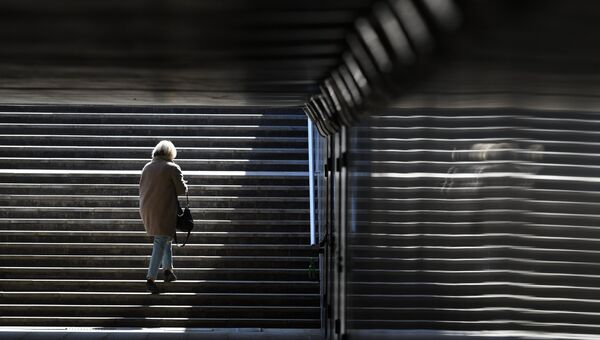 Женщина поднимается по лестнице подземного пешеходного перехода. Архивное фото