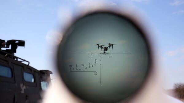 БПЛА через оптический прицел, за которым во время учений по борьбе с воздушными целями наблюдает военнослужащий
