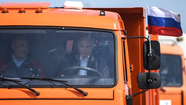 Президент РФ Владимир Путин за рулем автомобили КамАЗ во время проезда колонны строительной техники по автодорожной части Крымского моста на торжественной церемонии открытия транспортного перехода. 15 мая 2018
