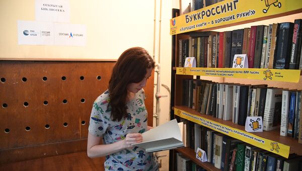 Читательница в импровизированной свободной библиотеке, организованной сайтом РИА Новости Крым и радиостанцией Спутник в Крыму