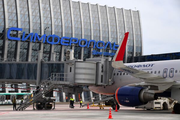 Самолет Аэрофлота у рукава для посадки и высадки пассажиров  нового терминала Крымская волна международного аэропорта Симферополь