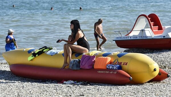 Отдыхающие загорают на пляже Коктебеля на берегу Черного моря