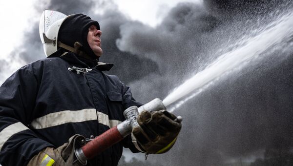 Сотрудник МЧС во время тушения пожара. Архивное фото