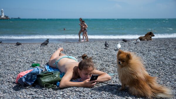Девушка с собакой на городском пляже ялтинской набережной им. Ленина
