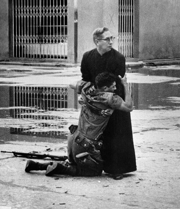 Священник Луис Падильо и солдат, раненый снайпером, во время восстания в Венесуэле. 1962 год
