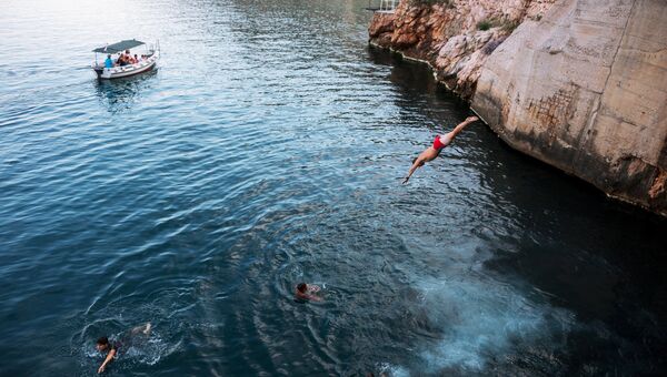 Дети прыгают в море со скал в Балаклаве
